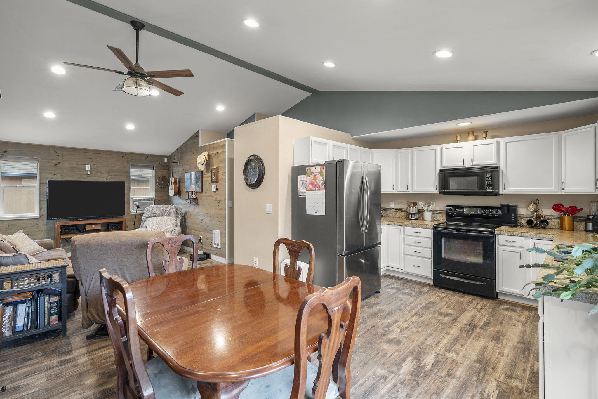 552 Southwest Lincoln Street Madras, OR 97741 - Photo 8 of 23 a kitchen with stainless steel appliances granite countertop a refrigerator a stove a sink a dining table and chairs with wooden floor