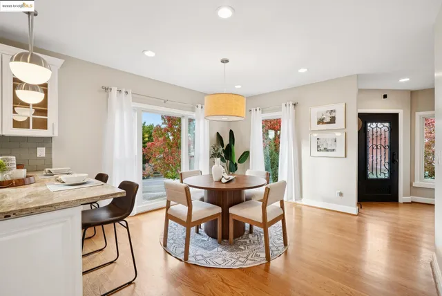 a dining room with furniture potted plants and wooden floor