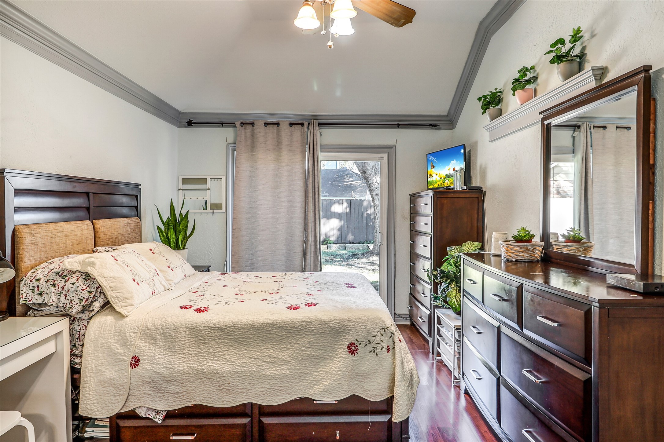15922 Riverside Grove Drive Houston, TX 77083 - Photo 12 of 23 a bedroom with a bed dresser and a chandelier
