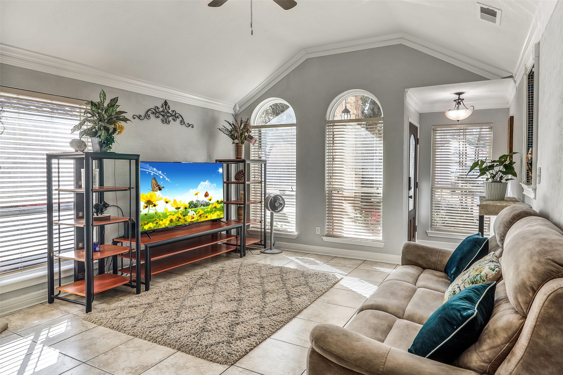 15922 Riverside Grove Drive Houston, TX 77083 - Photo 5 of 23 a living room with furniture a flat screen tv and a floor to ceiling window