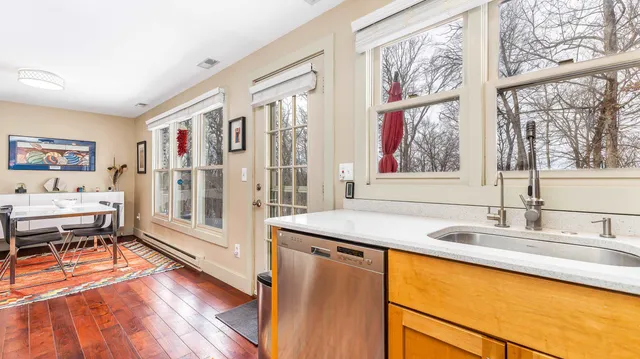 a kitchen with stainless steel appliances granite countertop a stove a sink and a refrigerator with wooden floor