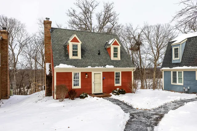 a front view of a house with a yard covered in snow