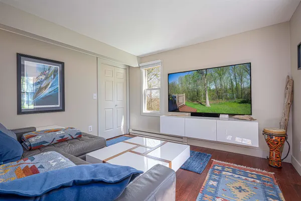 a bedroom with a bed a dresser next to a window