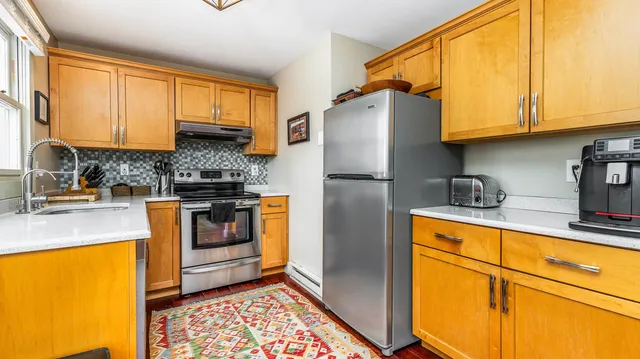 a kitchen with stainless steel appliances granite countertop a refrigerator a stove a sink and cabinets