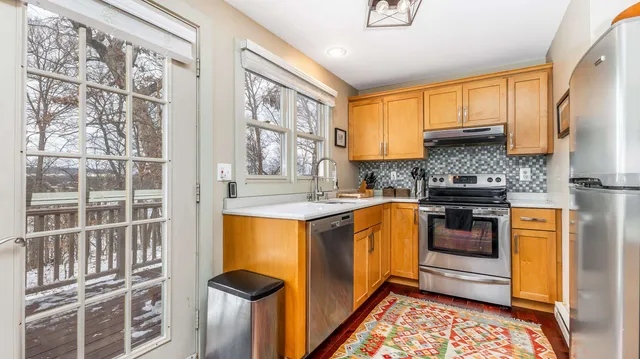 a kitchen with stainless steel appliances granite countertop a stove a sink and a refrigerator