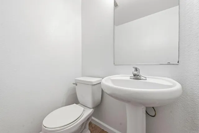 a bathroom with a sink a toilet and mirror