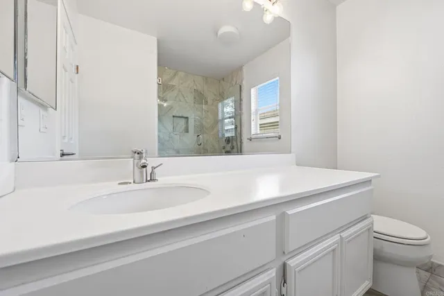 a bathroom with a sink a toilet and a mirror