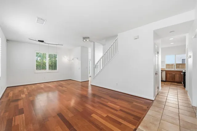 a view of a hallway with wooden floor and a bathroom