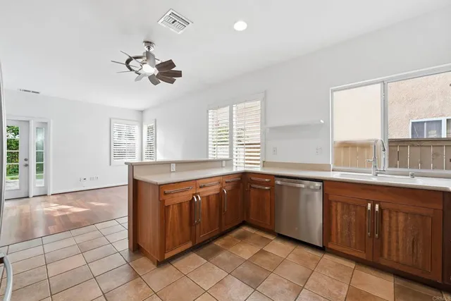 a large kitchen with stainless steel appliances granite countertop a sink and dishwasher a stove with wooden cabinets