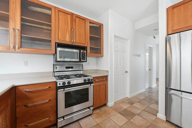 a kitchen with stainless steel appliances granite countertop a stove microwave and refrigerator