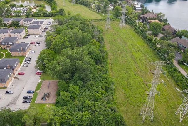 an aerial view of lake residential house with outdoor space and trees all around