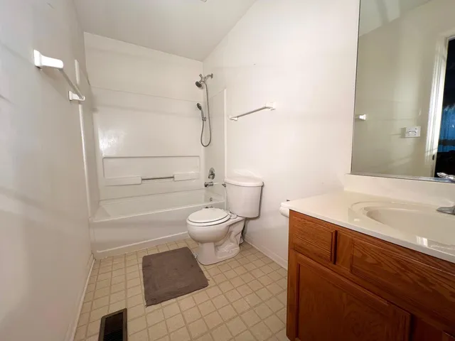 a bed sitting in a room next to a lamp