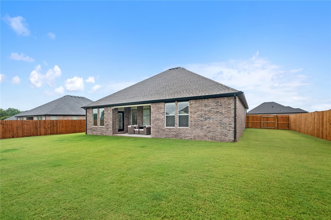 2105 Oliver Street Pea Ridge, AR 72751 - Photo 24 of 26 Spacious backyard featuring a covered patio, brick exterior, multiple windows, and a privacy fence