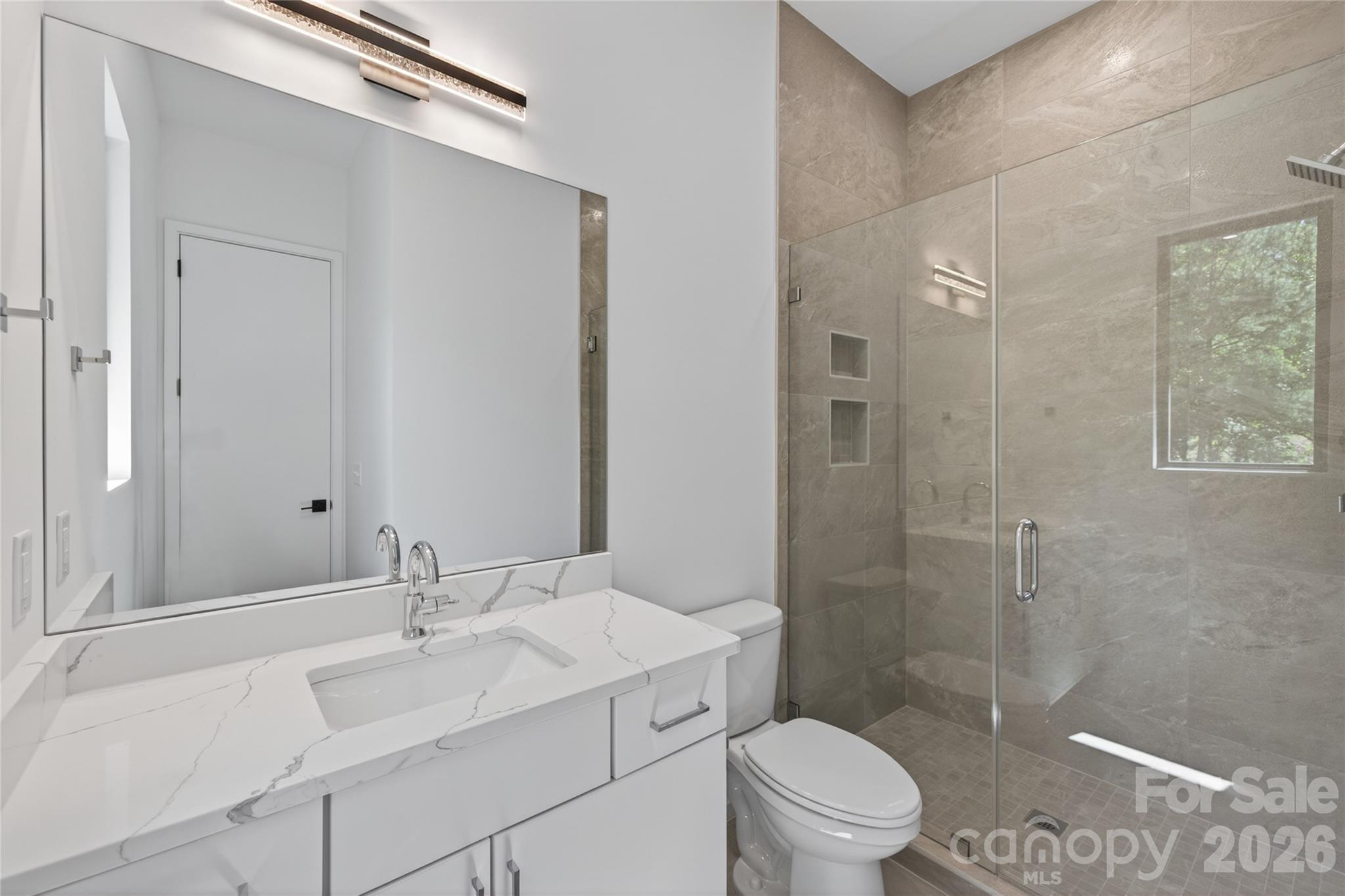 115 High Shores Road Norwood, NC 28128 - Photo 20 of 30 a bathroom with a sink toilet vanity and shower