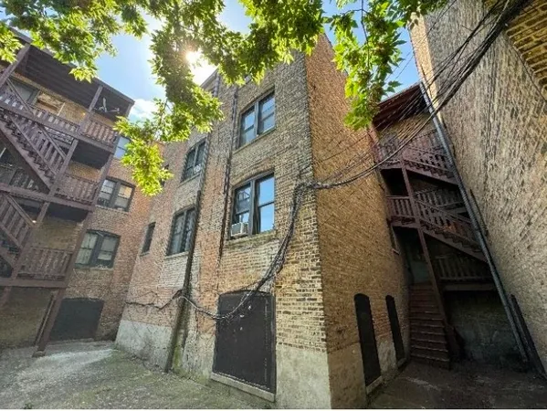 a brick building with a tree in front