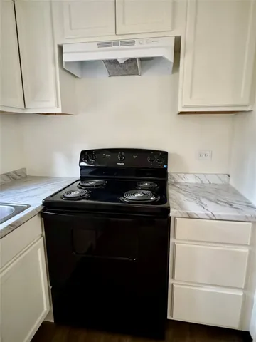 a kitchen with stainless steel appliances granite countertop a refrigerator sink and white cabinets