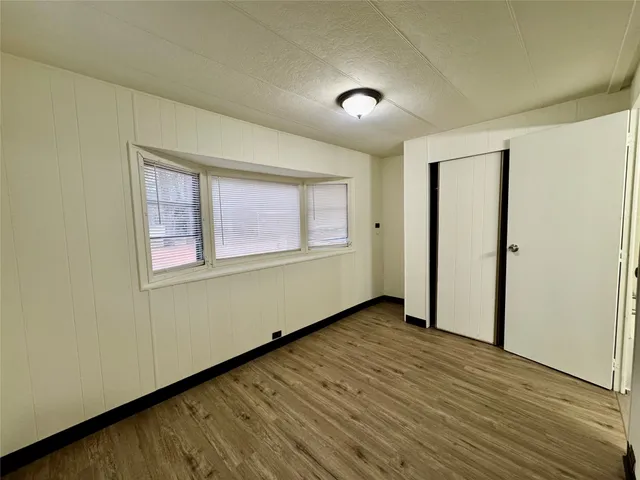 a view of a room with wooden floor and painting on the wall