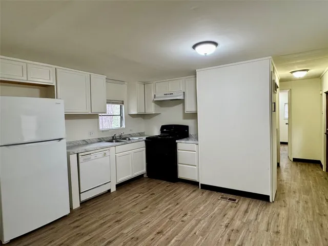 a kitchen with wooden cabinets and white appliances