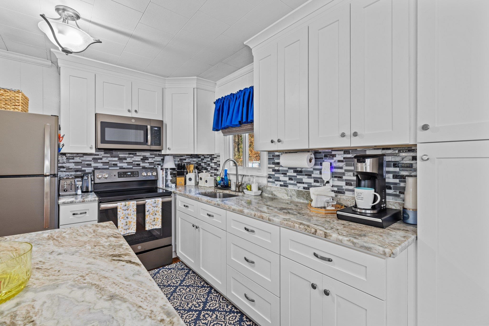 761 Jones Lester Road Roxboro, NC 27574 - Photo 13 of 27 a kitchen with granite countertop a sink a stove and refrigerator