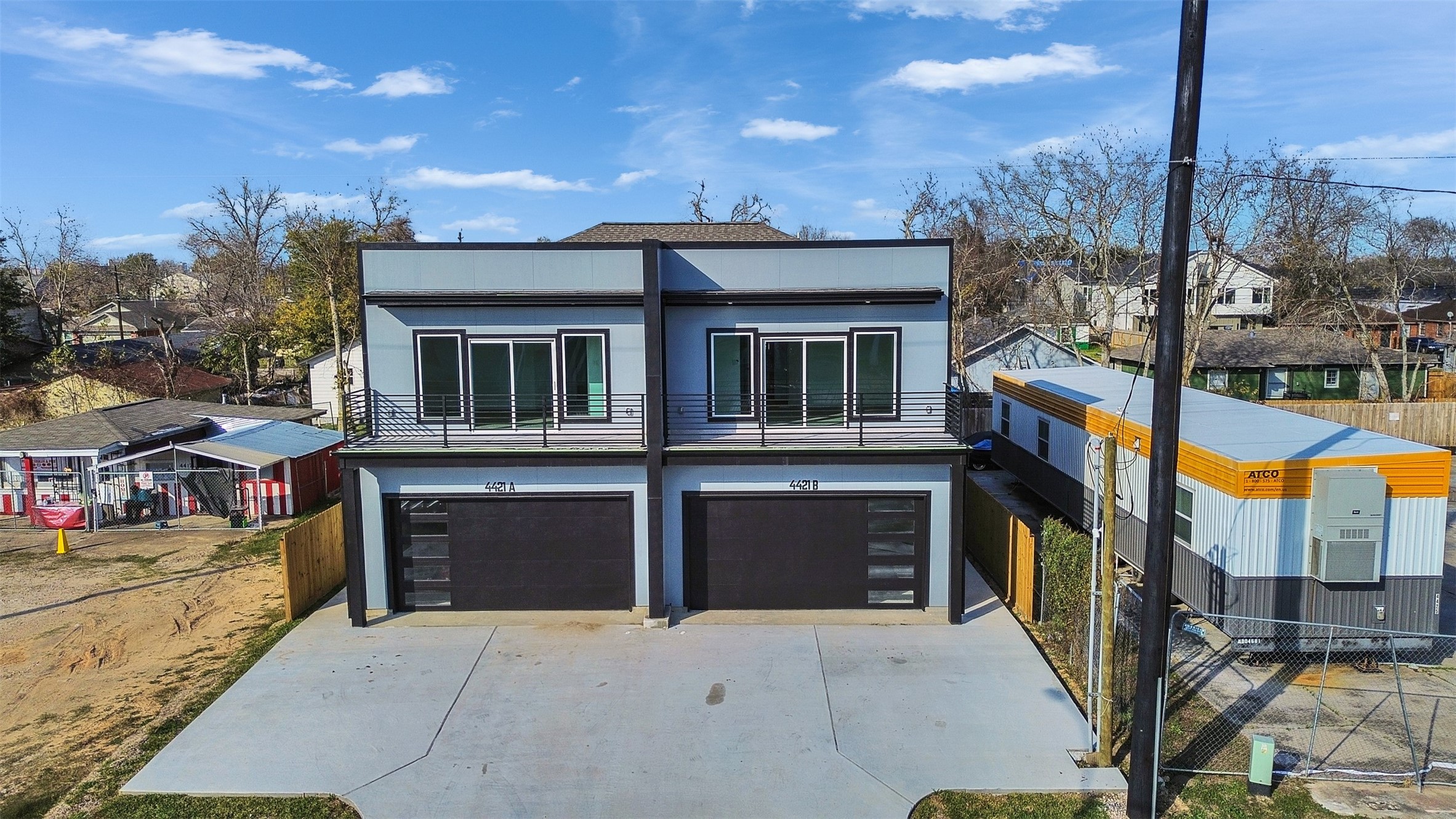 a front view of a building with glass windows and tree