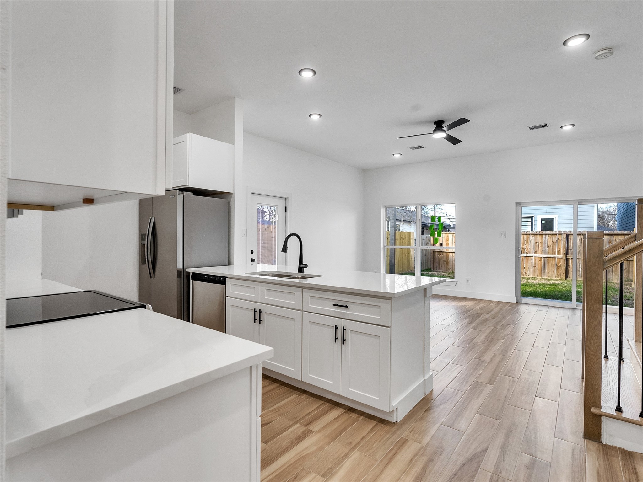 4421 Reed Road, Unit A AND B Houston, TX 77051 - Photo 9 of 39 a large white kitchen with a refrigerator a sink dishwasher a stove and a dining table with wooden floor