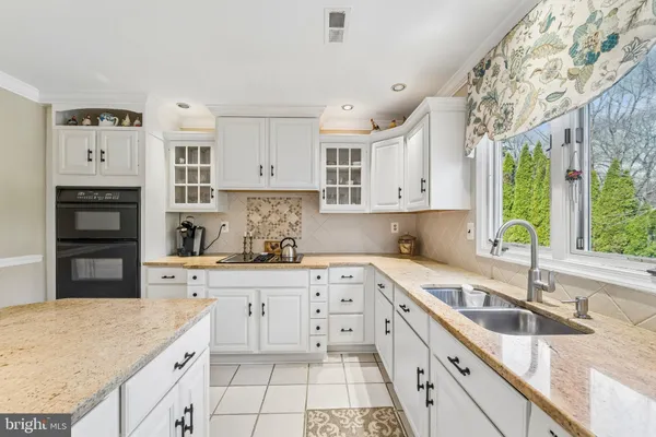 a kitchen with granite countertop a sink stainless steel appliances and cabinets