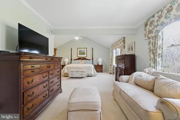 a spacious bedroom with a bed and a chandelier