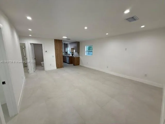 an empty room with a refrigerator and a sink