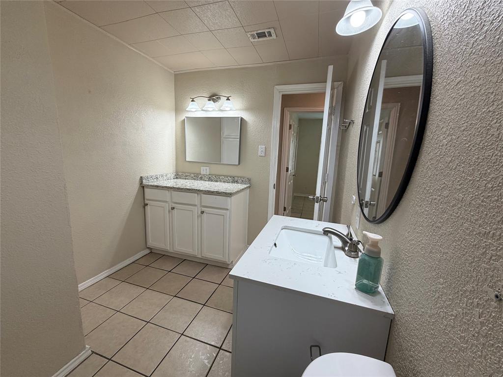 532 Northwest King Street Burleson, TX 76028 - Photo 11 of 17 a bathroom with a sink mirror and toilet
