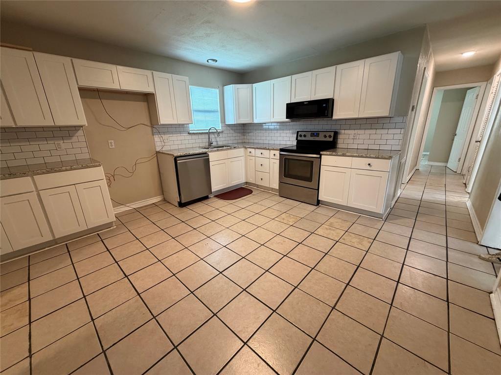 532 Northwest King Street Burleson, TX 76028 - Photo 5 of 17 a kitchen with stainless steel appliances a refrigerator sink and microwave