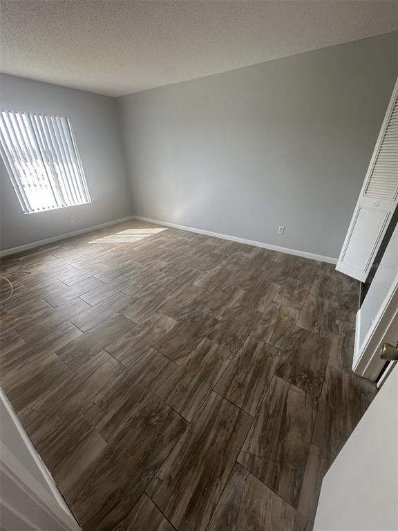 8215 Sun Spring Circle, Unit 63 Orlando, FL 32825 - Photo 13 of 22 an empty room with wooden floor and windows