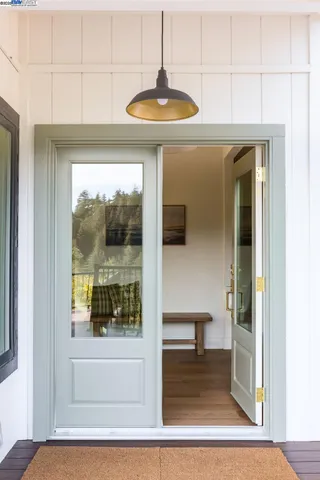 a view of a hallway with a dining table and chandelier