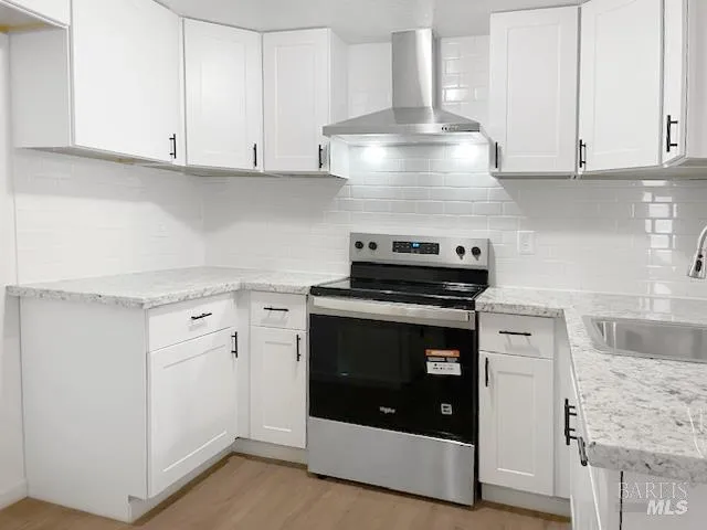 a kitchen with stainless steel appliances granite countertop white cabinets and a stove a refrigerator with white countertops