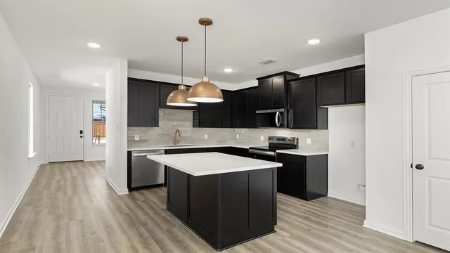 a kitchen with stainless steel appliances granite countertop a sink a stove and a refrigerator