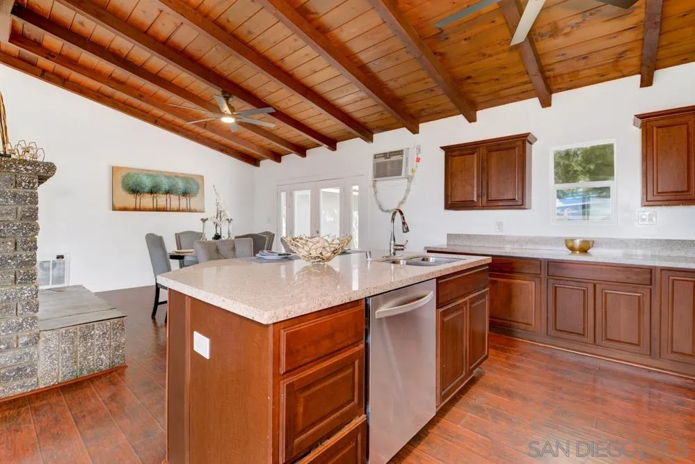 1105 Hamlet Drive El Cajon, CA 92021 - Photo 7 of 26 a kitchen with stainless steel appliances granite countertop a sink a stove top oven a chimney and a large window