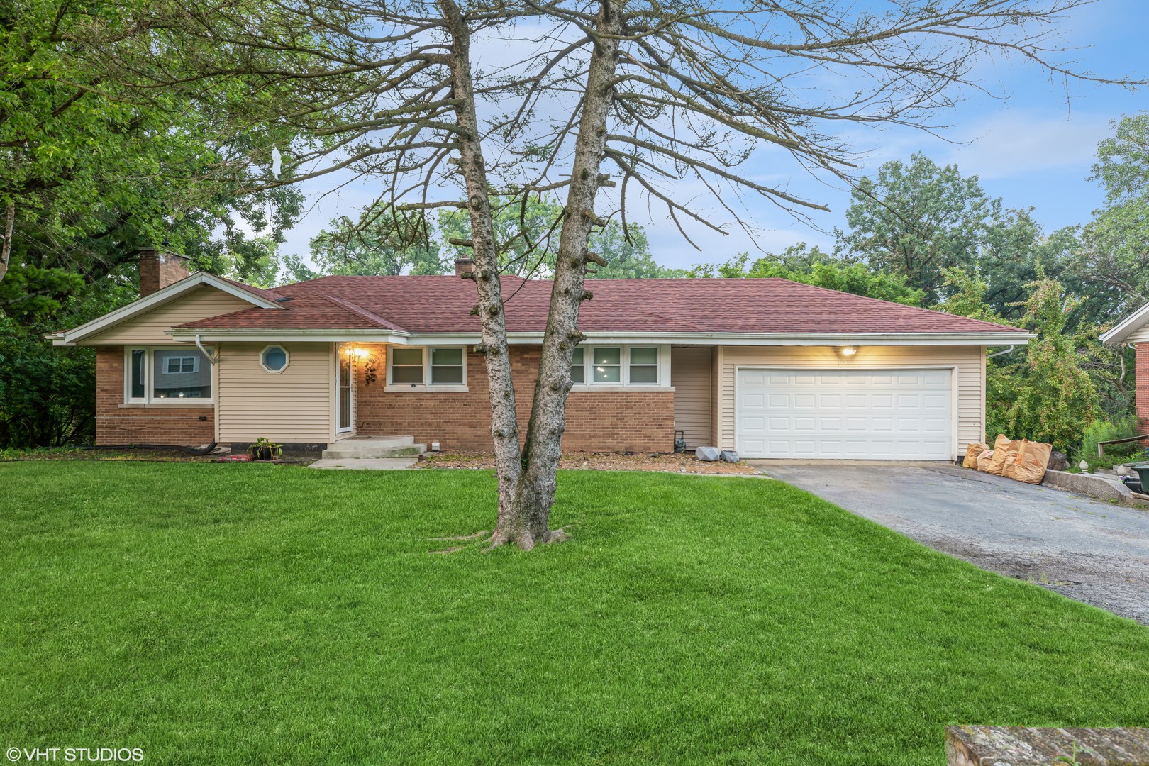a view of a yard in front of a house with large tree