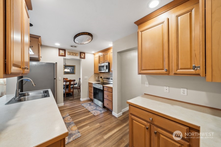 2007 Park Enumclaw Wa 98022 Enumclaw, WA 98022 - Photo 8 of 34 a kitchen with stainless steel appliances a sink a stove and a refrigerator with wooden floor