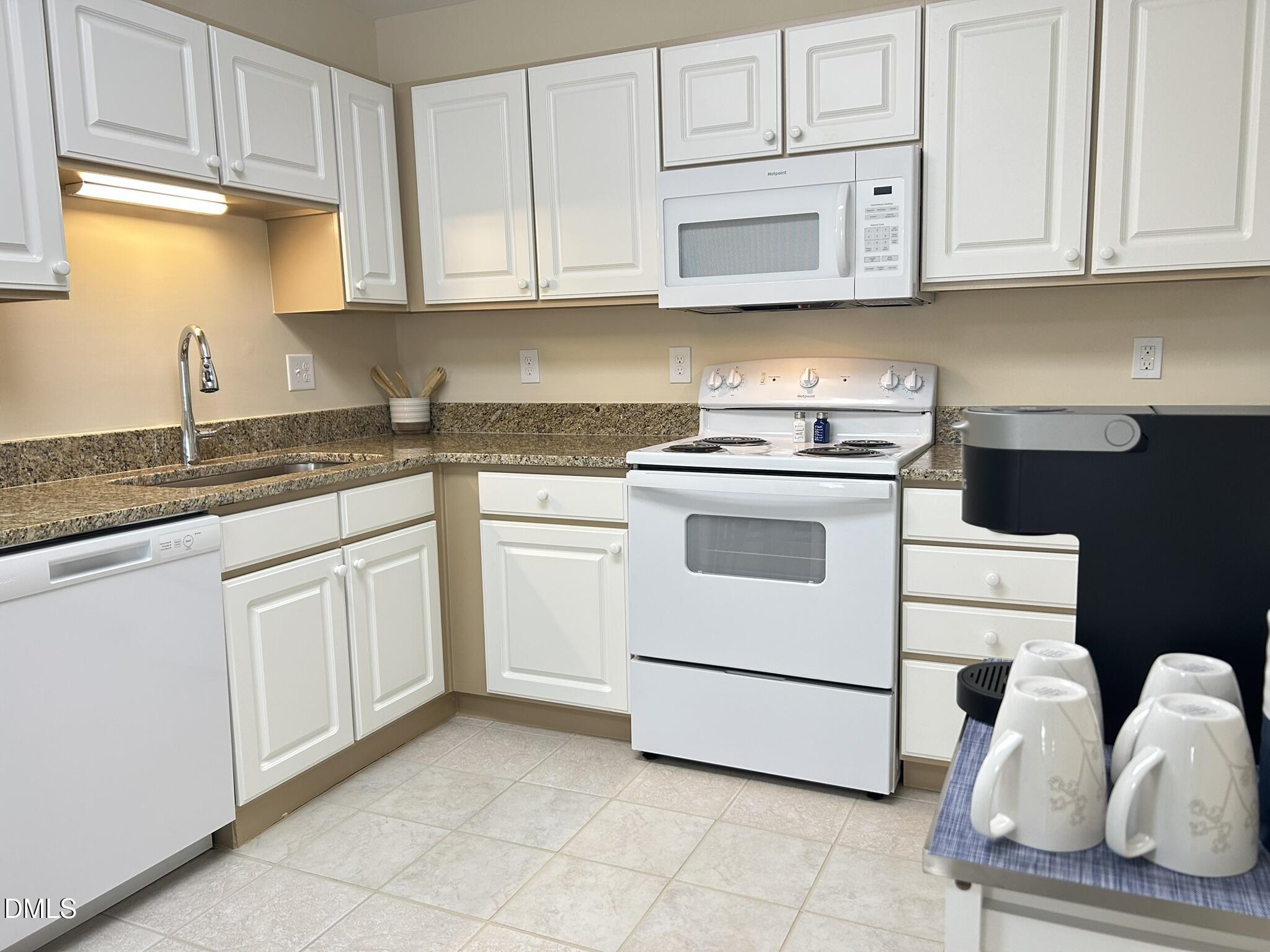 2510 Friedland Place, Unit 102 Raleigh, NC 27617 - Photo 9 of 42 a kitchen with granite countertop white cabinets and white appliances
