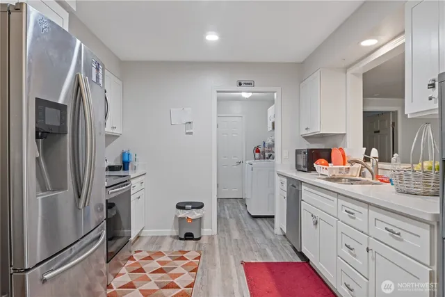 a kitchen with stainless steel appliances granite countertop a refrigerator and a sink