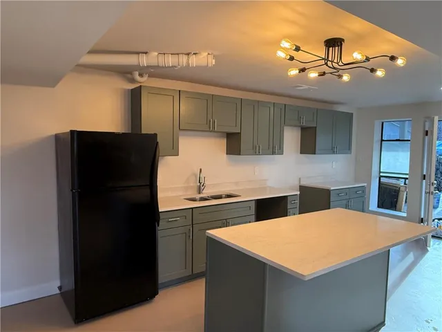 a kitchen with stainless steel appliances kitchen island a refrigerator sink and cabinets