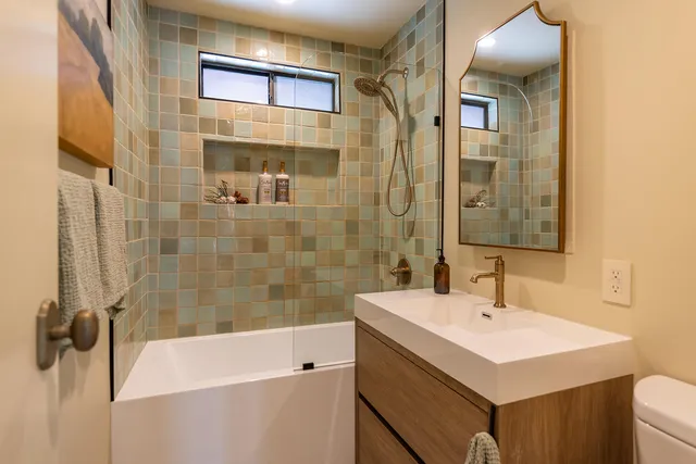 a bedroom with a bed a mirror and paintings on the wall