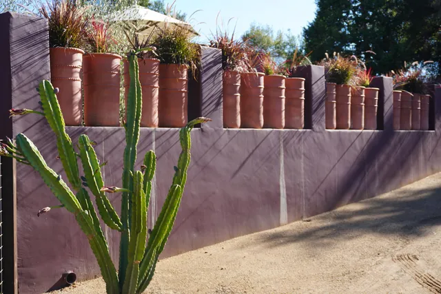a view of a backyard with table and chairs with a fire pit and large trees