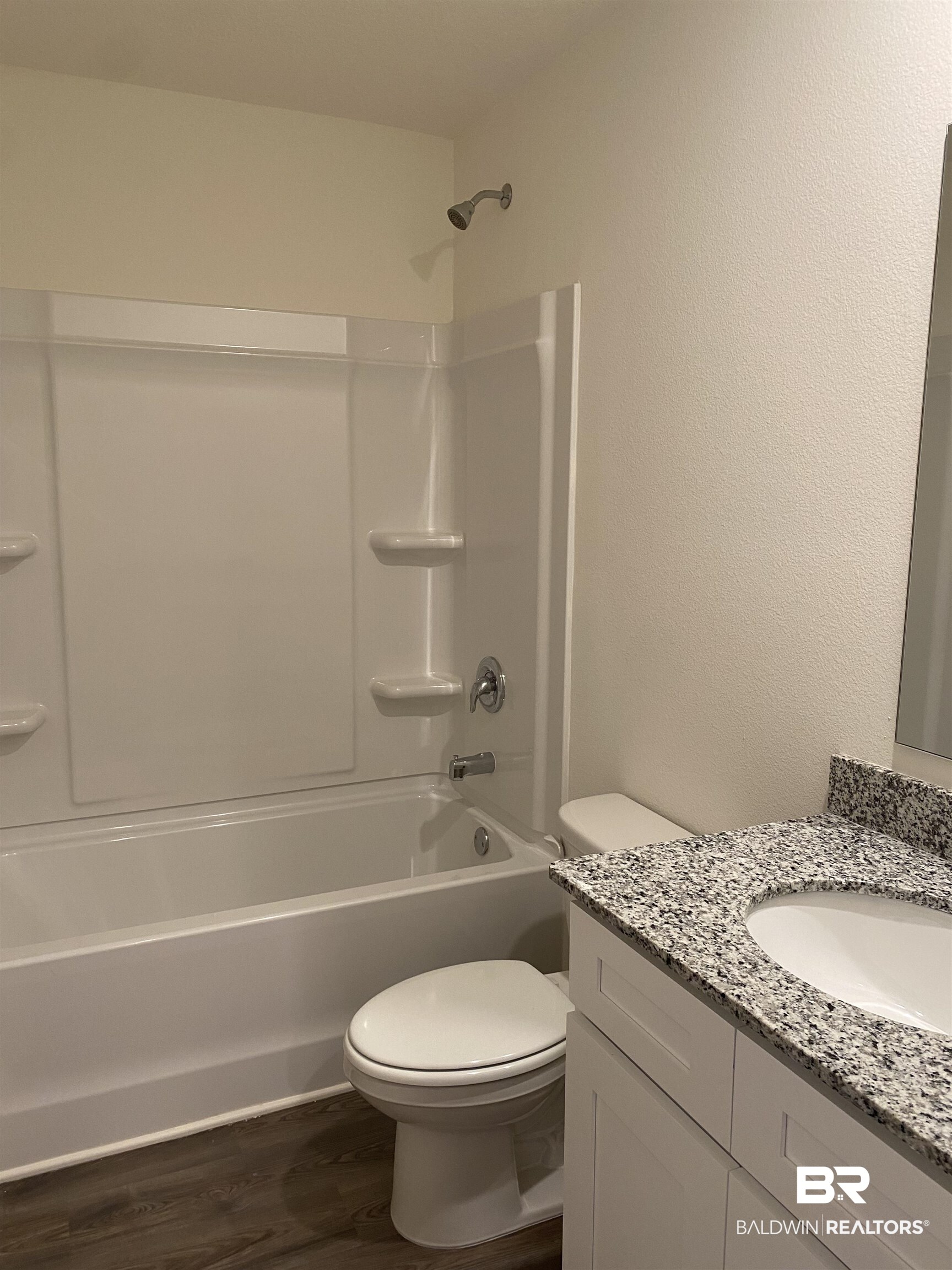 21676 Yosemite Boulevard Fairhope, AL 36532 - Photo 12 of 19 Full bathroom with washtub / shower combination, hardwood / wood-style floors, vanity, and toilet