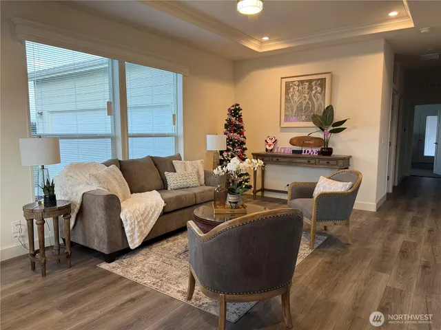 a living room with furniture wooden floor and a large window