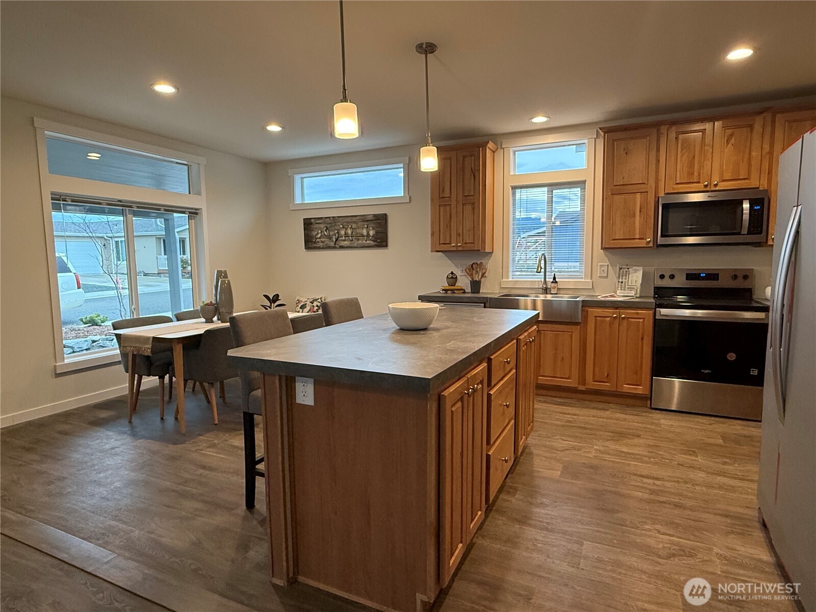 Undisclosed Address Sequim, WA 98382 - Photo 4 of 11 a kitchen with stainless steel appliances granite countertop a stove a sink a microwave a dining table and chairs