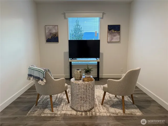 a living room with furniture a flat screen tv and a window