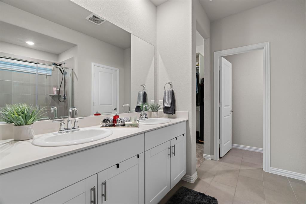3112 Kingsgarden Road Denton, TX 76207 - Photo 29 of 38 Dual vanity with white cabinetry, polished chrome hardware, and light-toned countertops