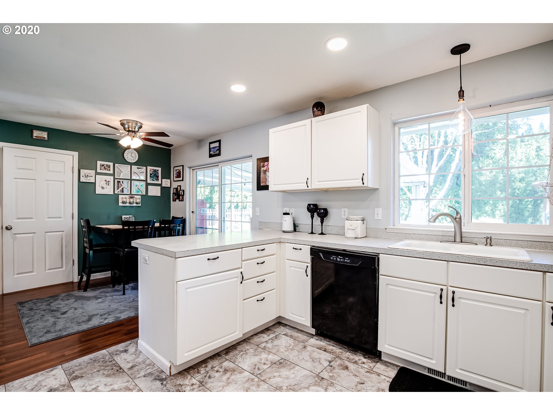 591 68th Place Springfield, OR 97478 - Photo 10 of 31 a kitchen with white cabinets a sink a window and stainless steel appliances