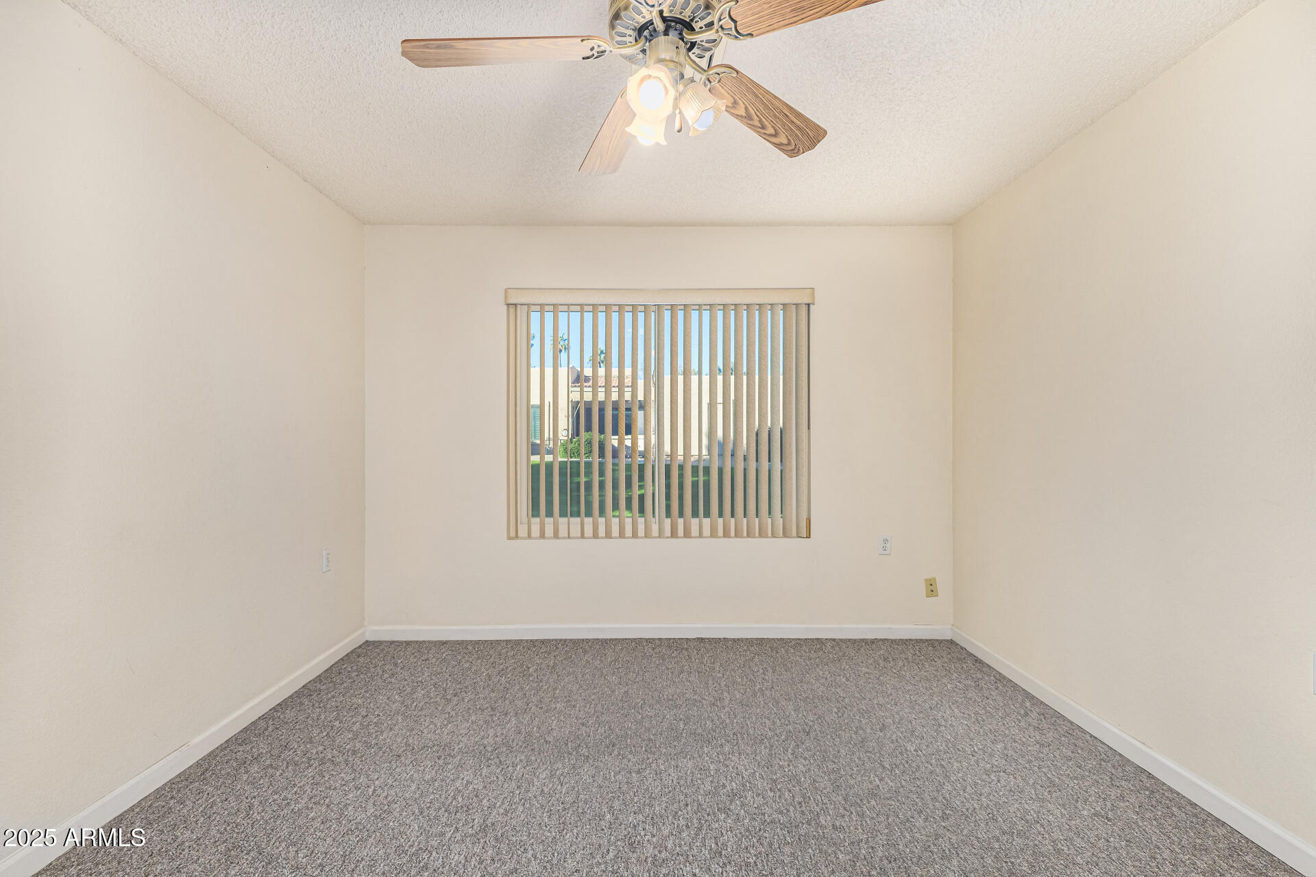 14300 West Bell Road, Unit 440 Surprise, AZ 85374 - Photo 16 of 40 an empty room with a chandelier fan and windows
