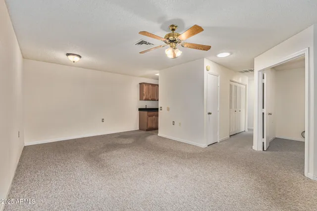 an empty room with fan and windows